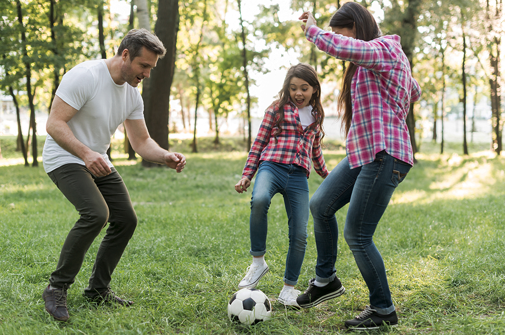 Cheerful Girl Playing Soccer Ball With Her Parent Grass Park