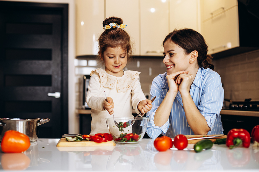 Mother With Little Daughter Preparing Salad