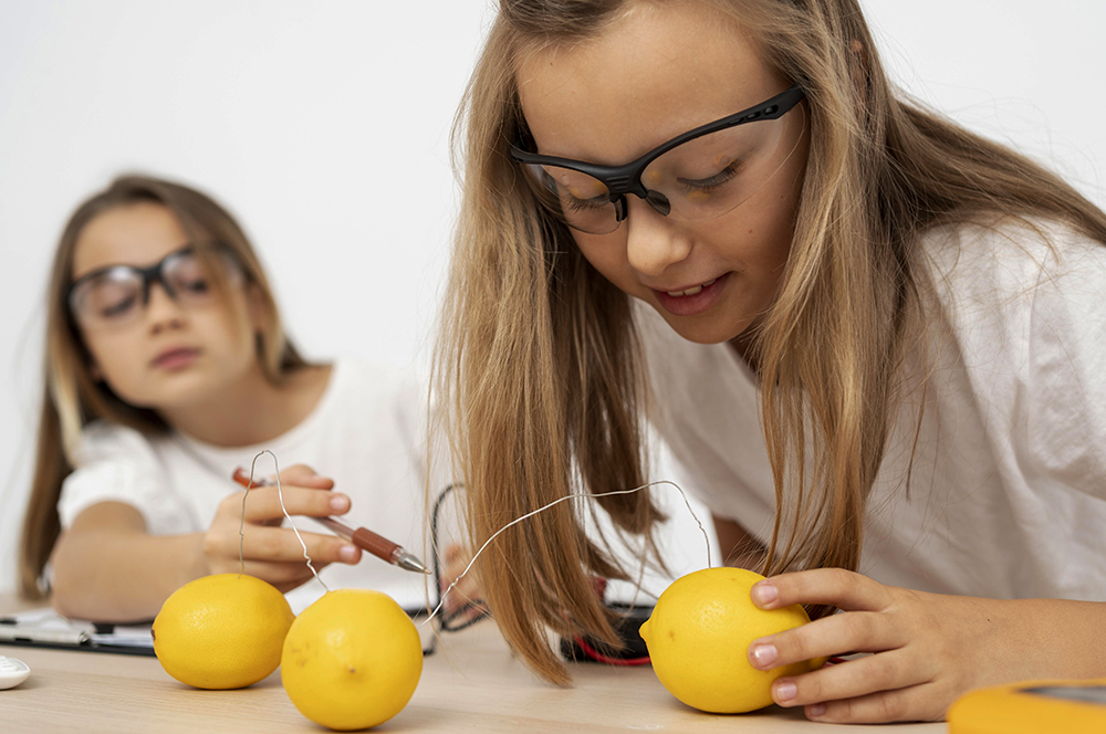 Two Girls Doing Science Experiments With Electricity Lemons